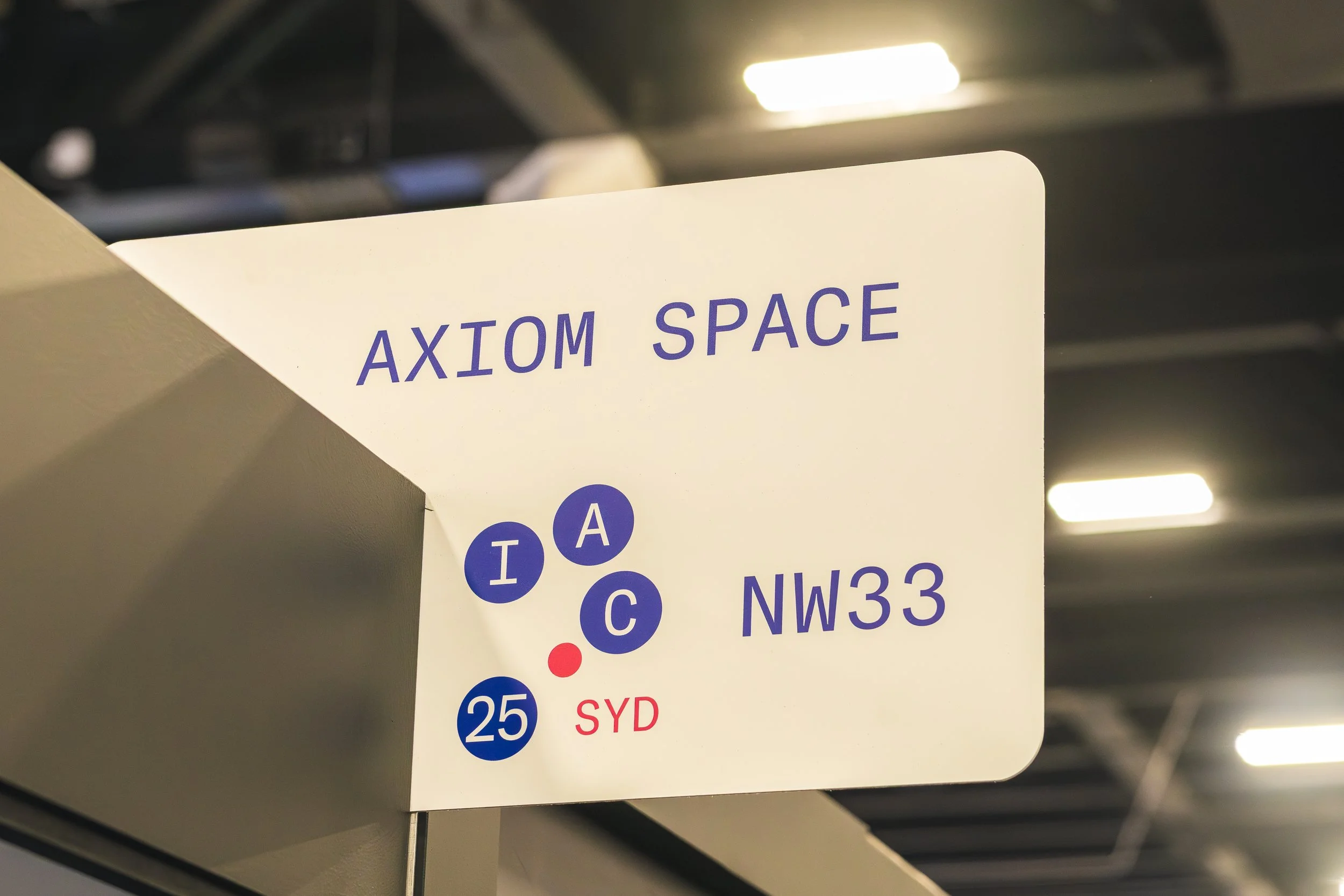 Close-up of a subway station sign displaying part of a route map with a focus on the label 'AXIOM SPACE' and train lines including T, A, C, and SYD.