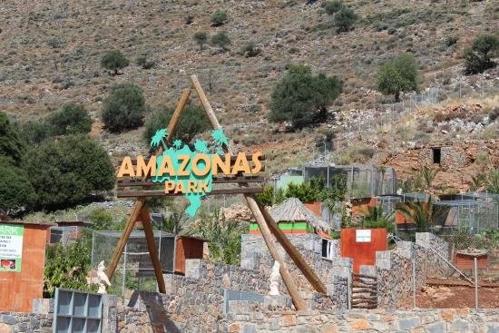 Taxi in Makry Gialos & Ierapetra - Sign for Amazonas Park with a hillside in the background.