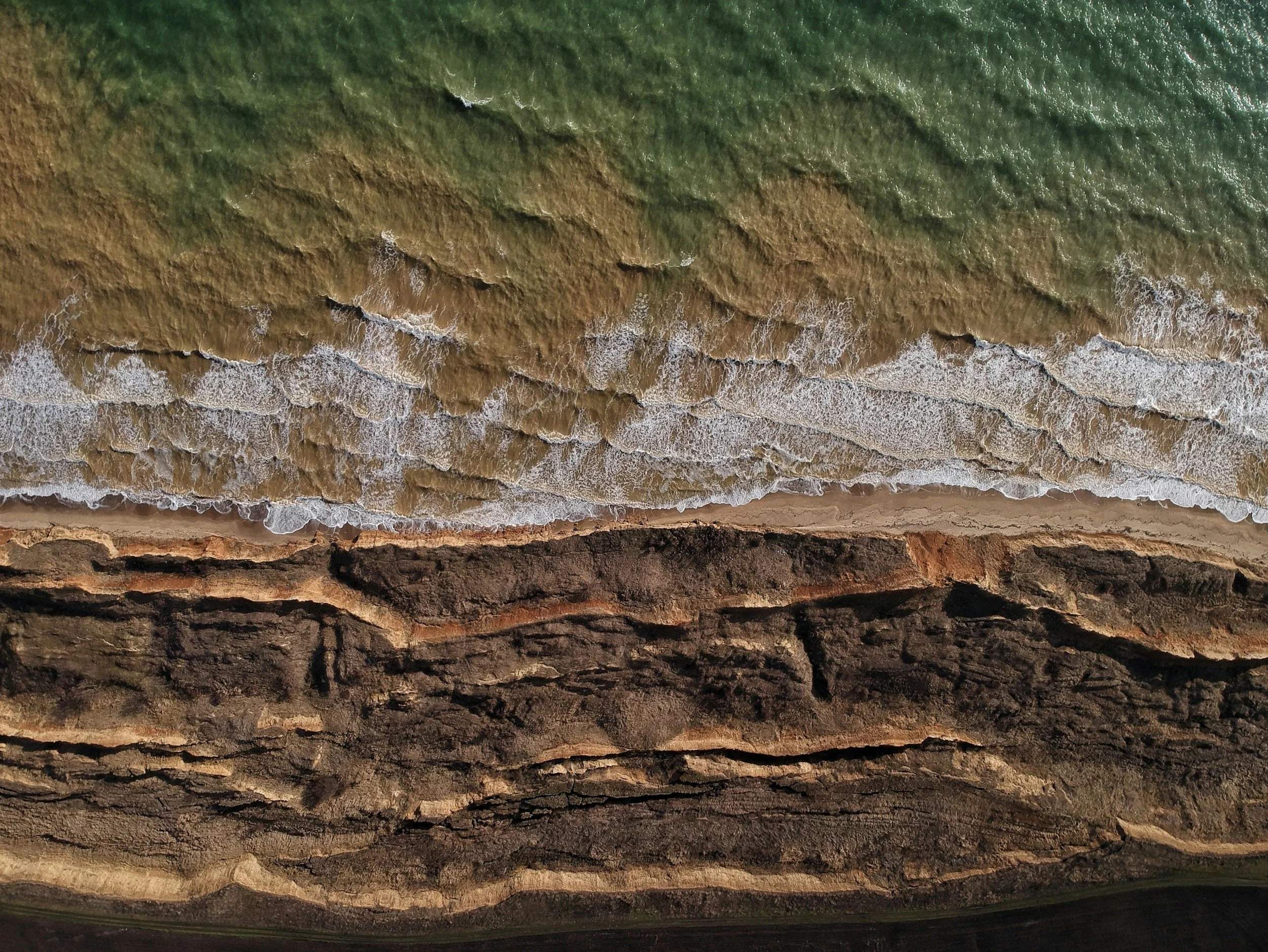 Layers of ocean and rock representing information gathered about a business across AI platforms.