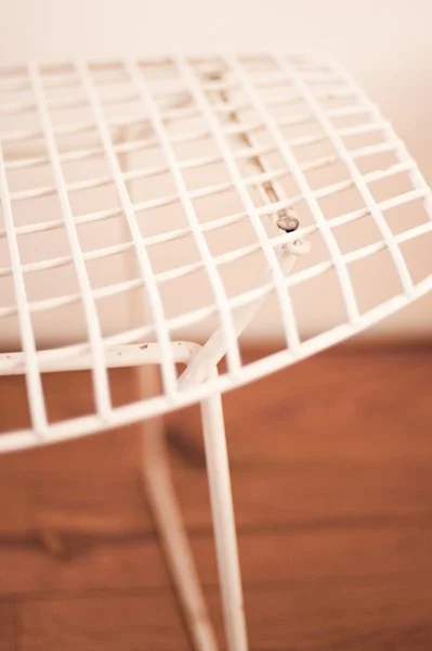 Vue d'une grille d'étendoir à linge blanc en métal sur un fond en bois.