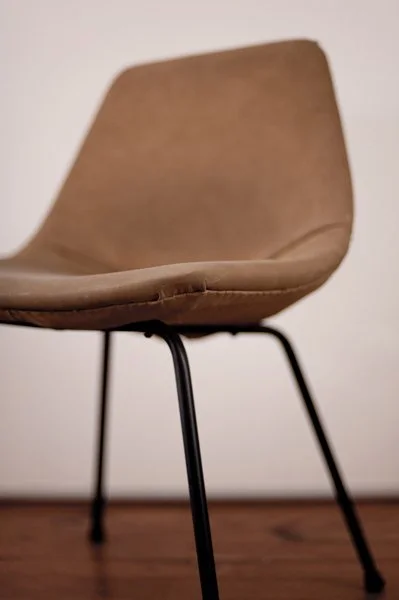 Chaise en bois avec cadre en métal, vue de côté sur un fond blanc et un sol en bois.