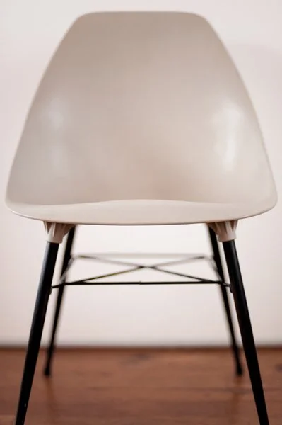Chaise blanche avec cadre métallique noir sur un sol en bois