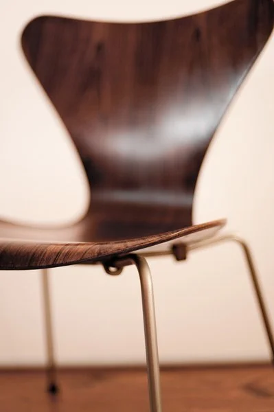 Chaise en bois courbée avec des jambes en métal, vue rapprochée.