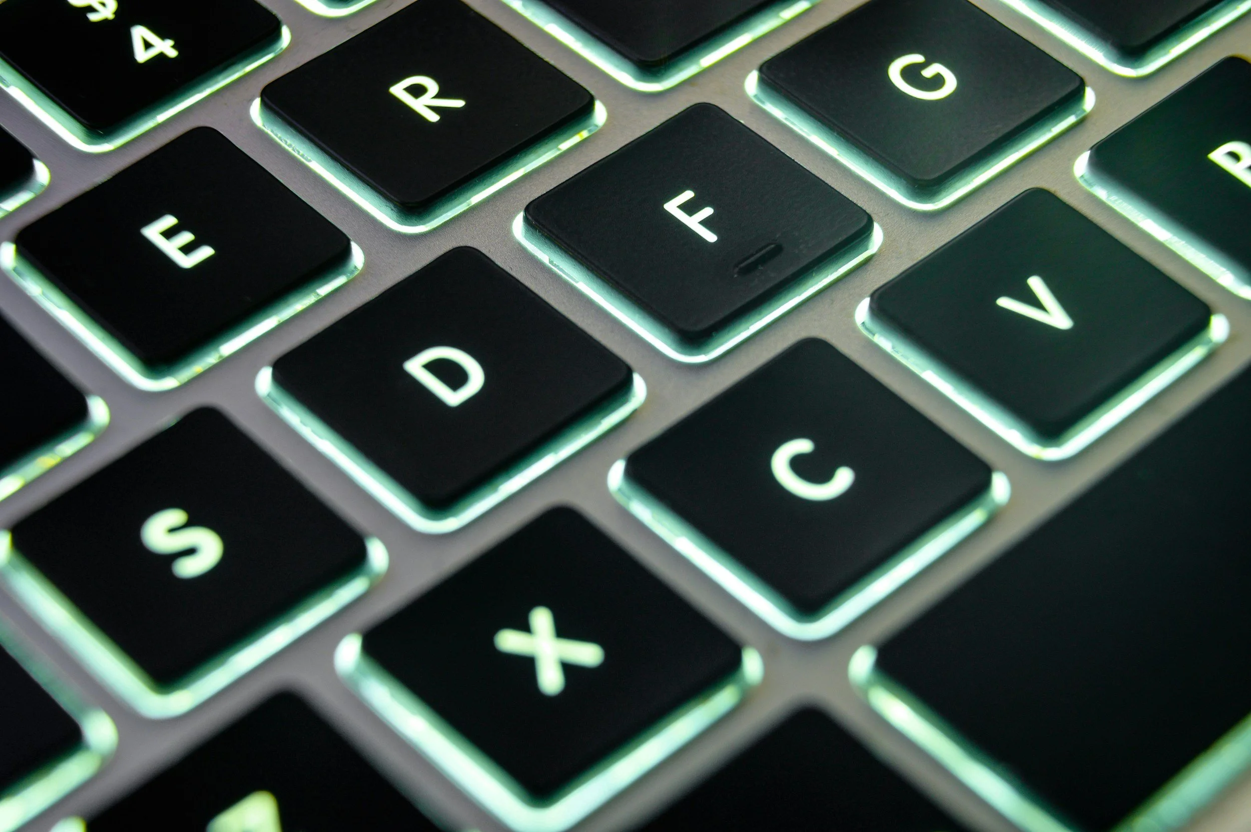 Keyboard close-up with green backlight for key