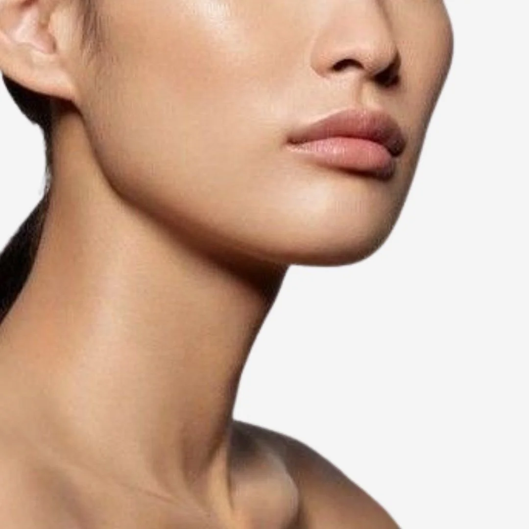 Close-up of a woman's lower face, neck, and shoulder, with smooth skin and full lips.