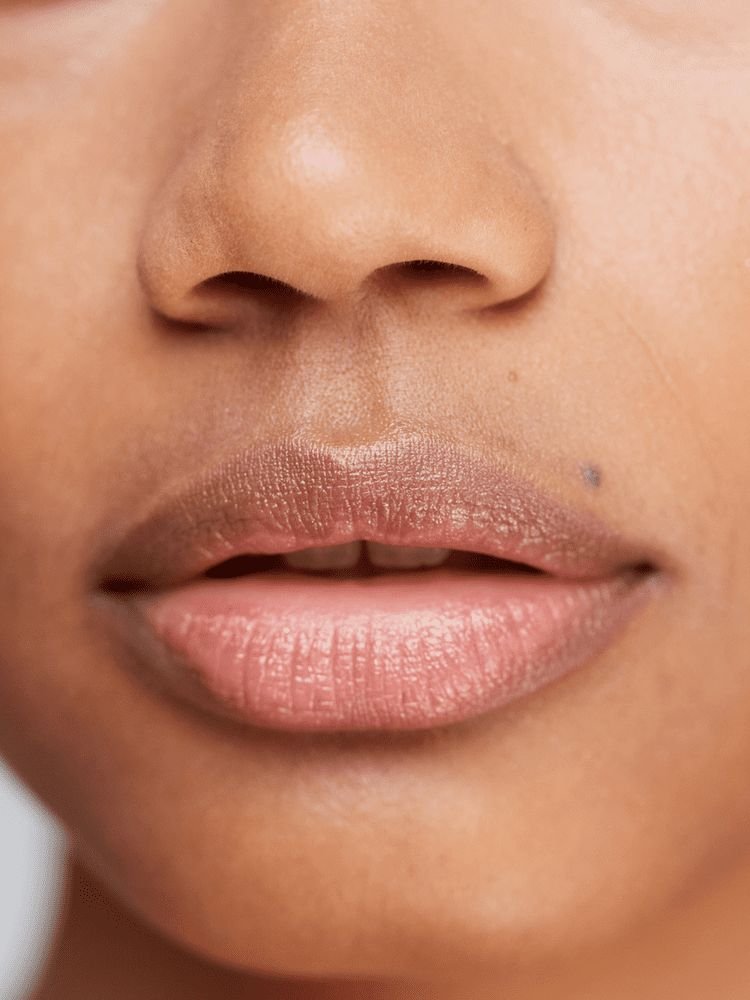 Close-up of a person's nose and lips, with a small mole near the right side of the upper lip.