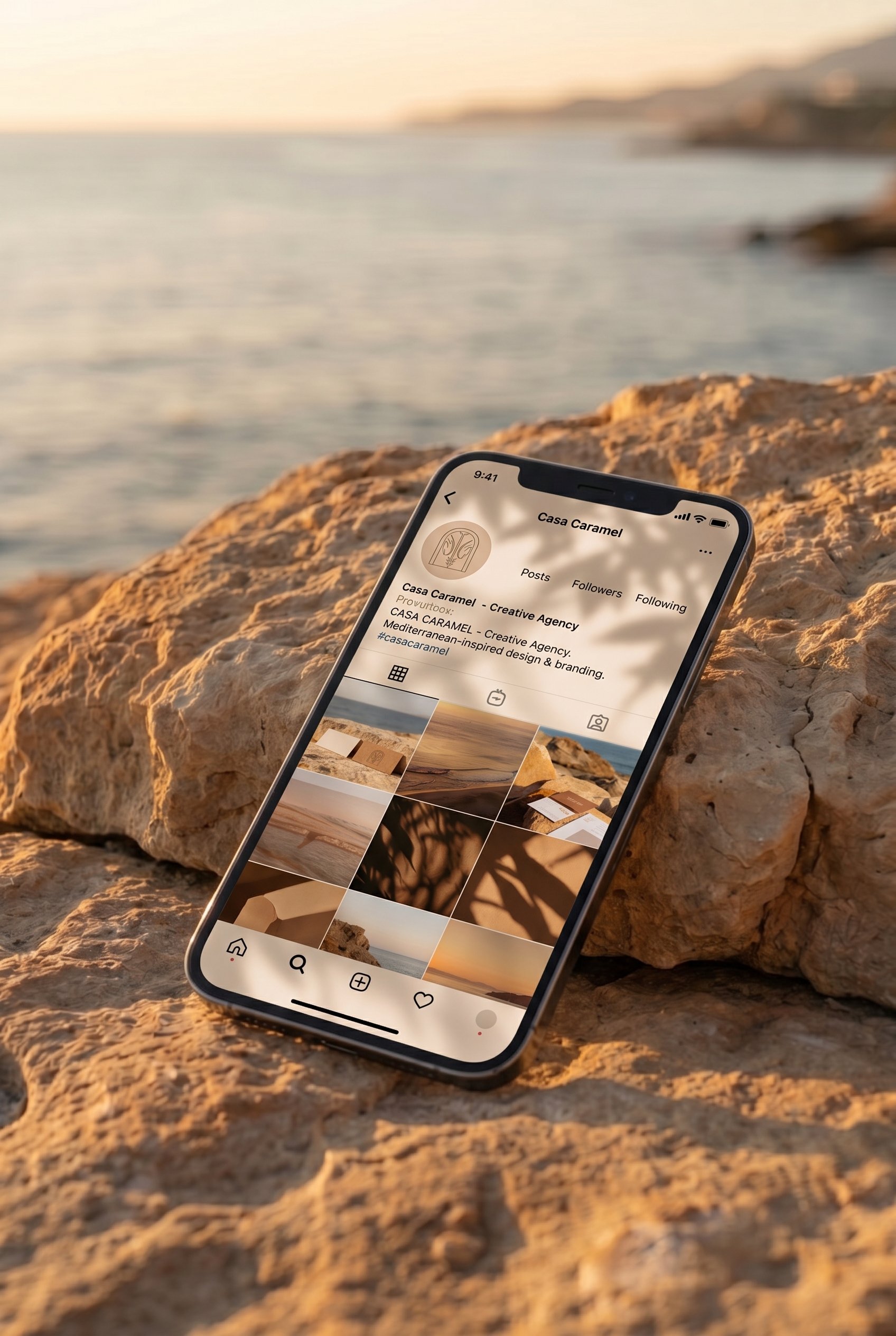Smartphone displaying Casa Caramel's Instagram profile on a rock backdrop, showcasing social media management services