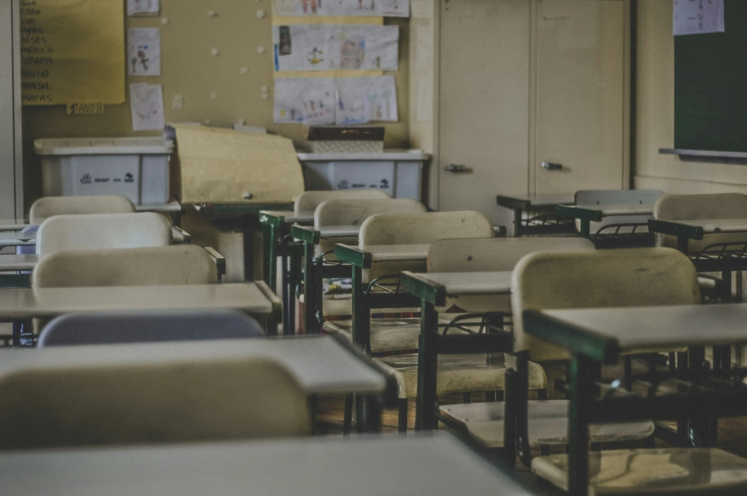 An image of an empty classroom, with rows of desks.