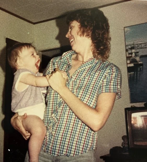 Judy holding her daughter, both laughing