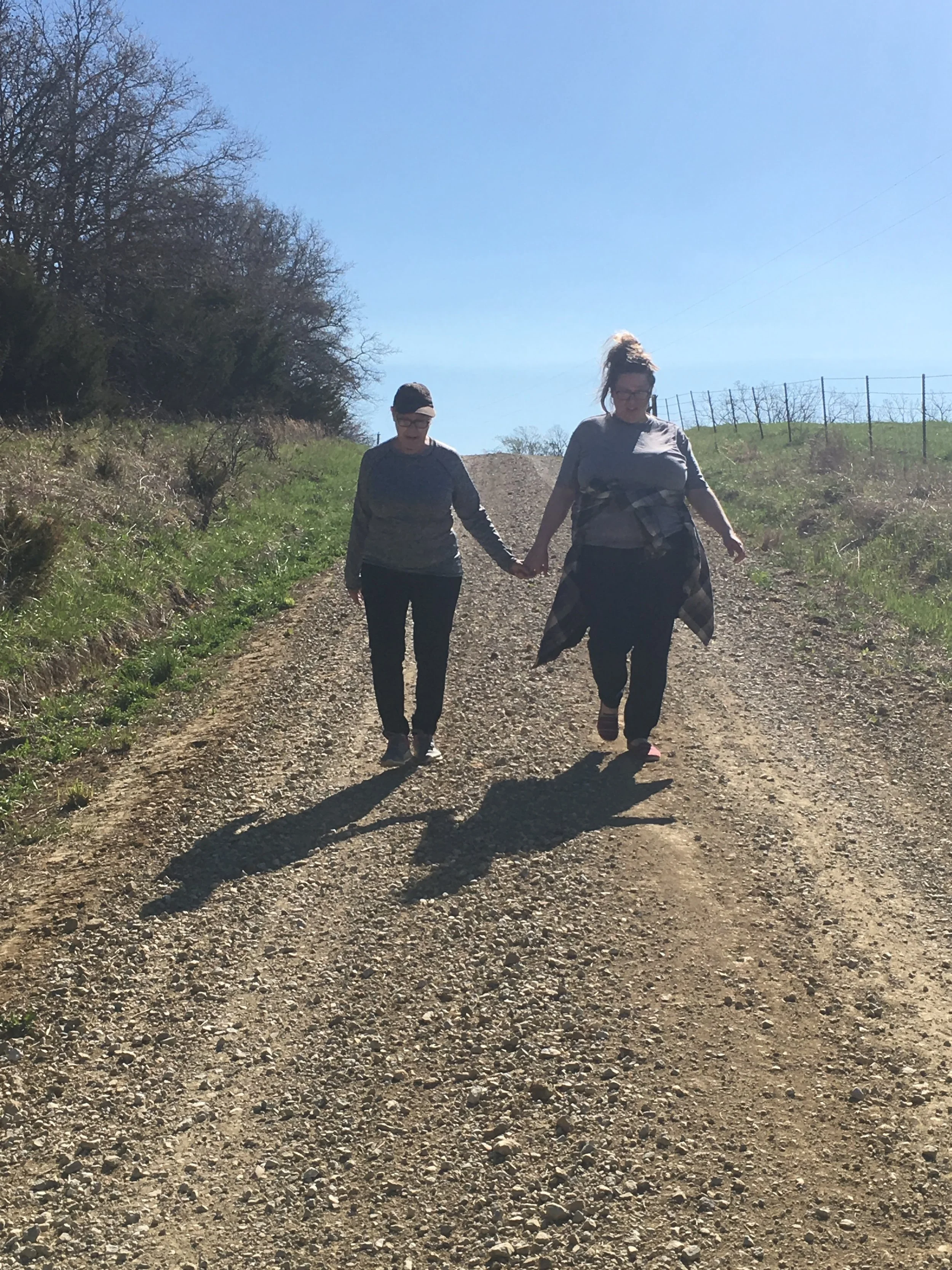 Judy and adult daughter walking near her cabin