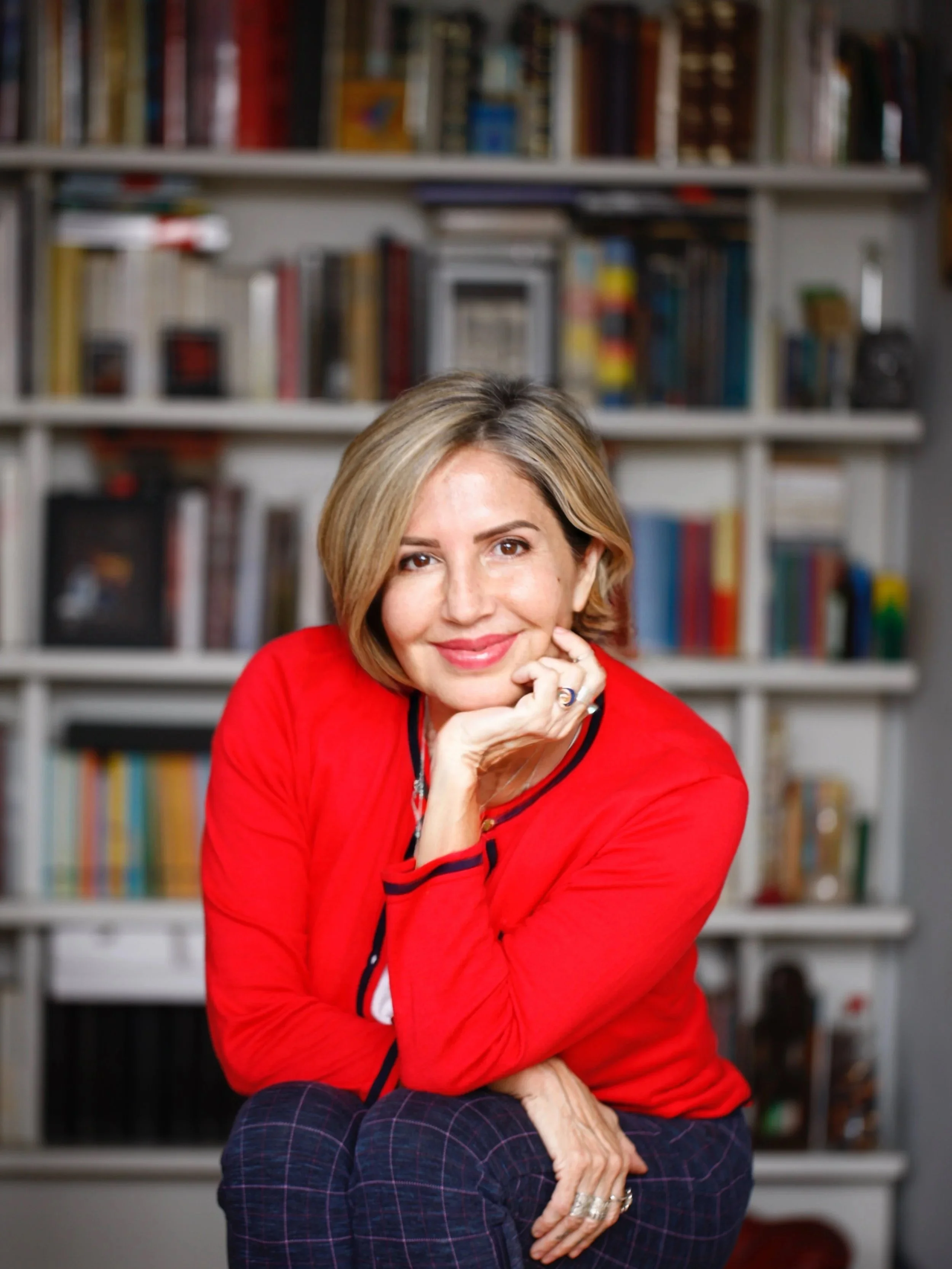 paz  nilo looking at the camera in a red cardigan, smiling