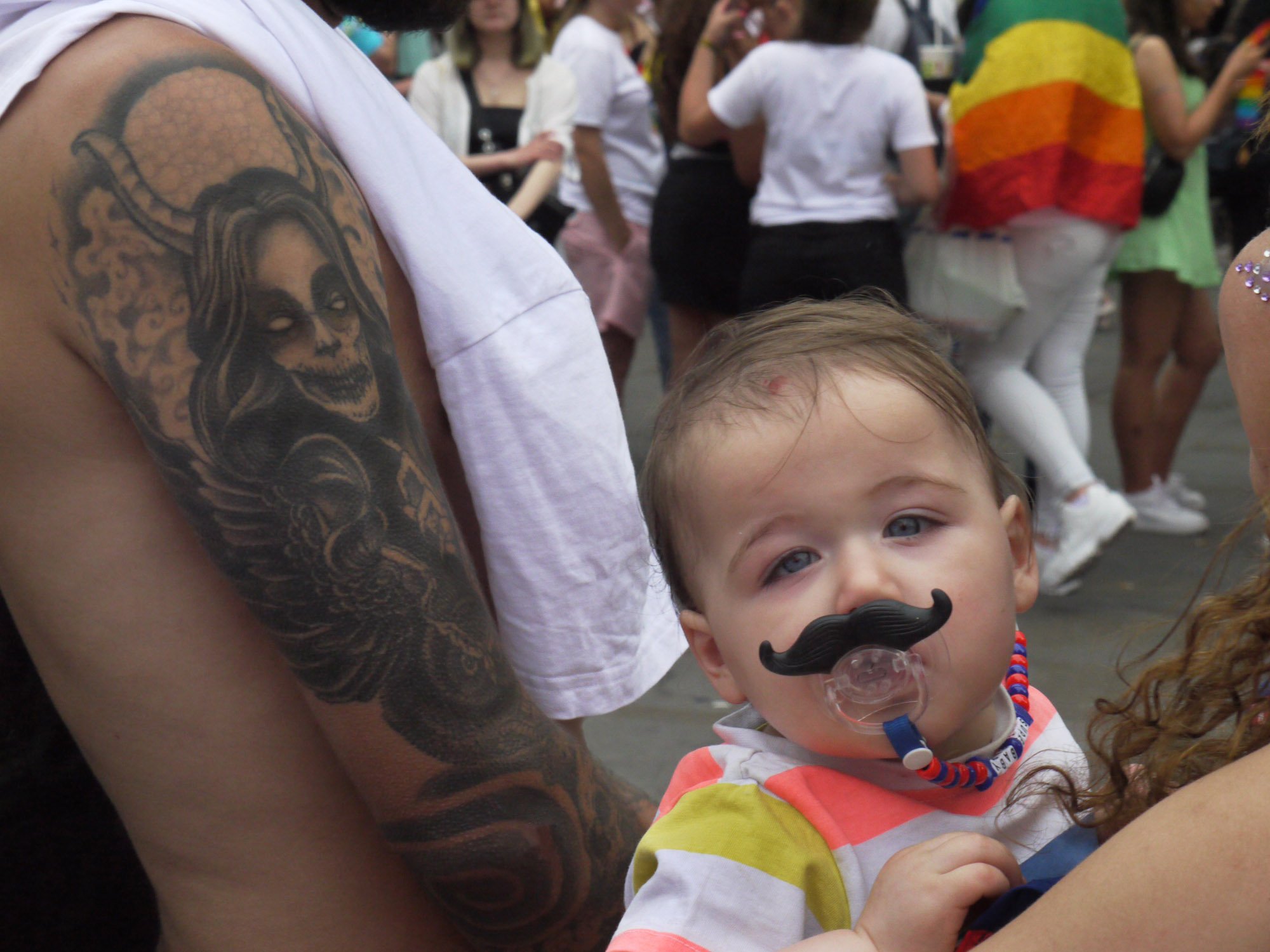 Bob Watkins   P1150842  Pride London   July 2019   Man with devil tattoo and baby with moustache  .jpg