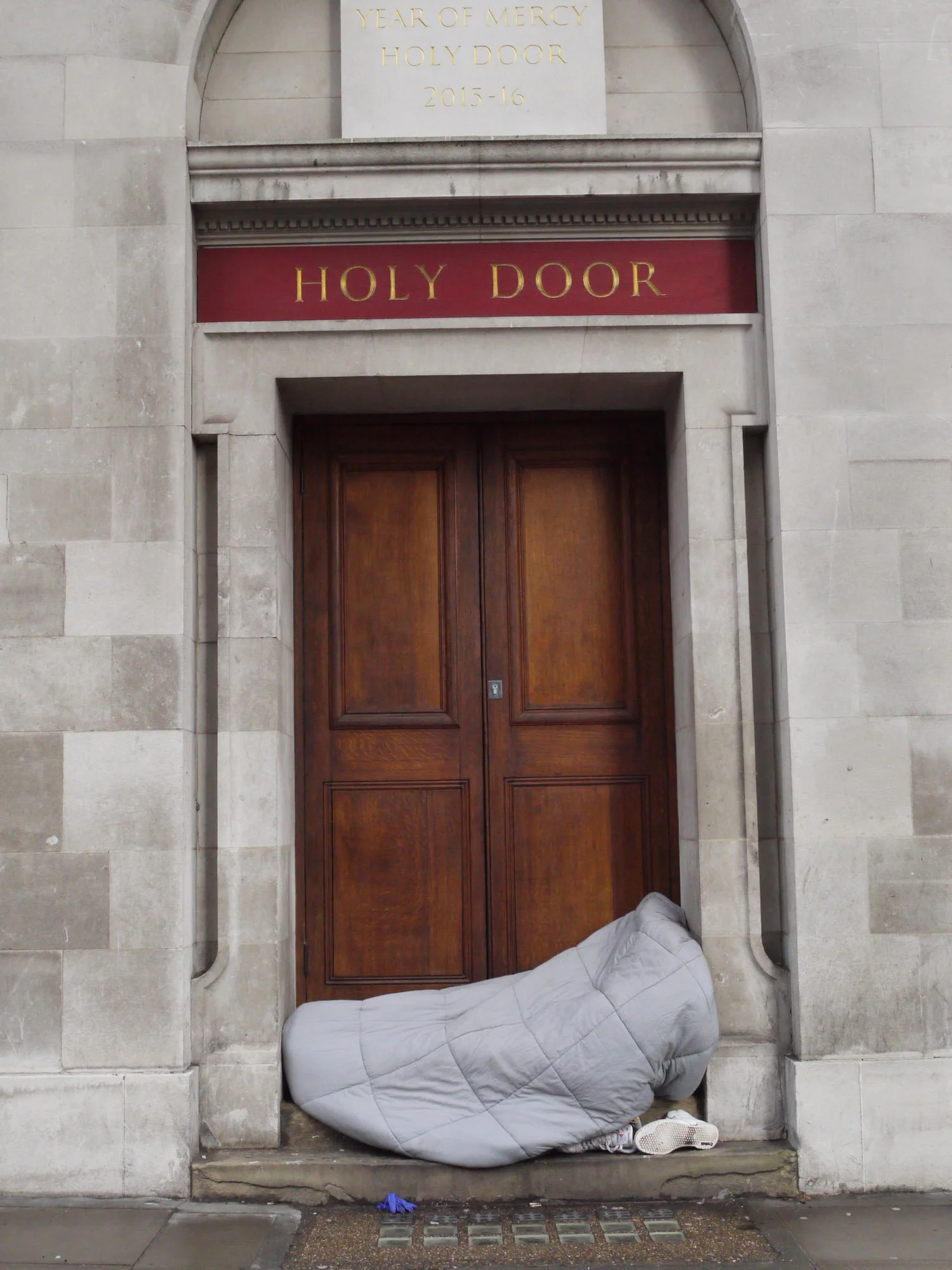 Bob Watkins  P1210311 Kingsway London  March 2022   Homeless bed in doorway marked Holy Door    .jpg