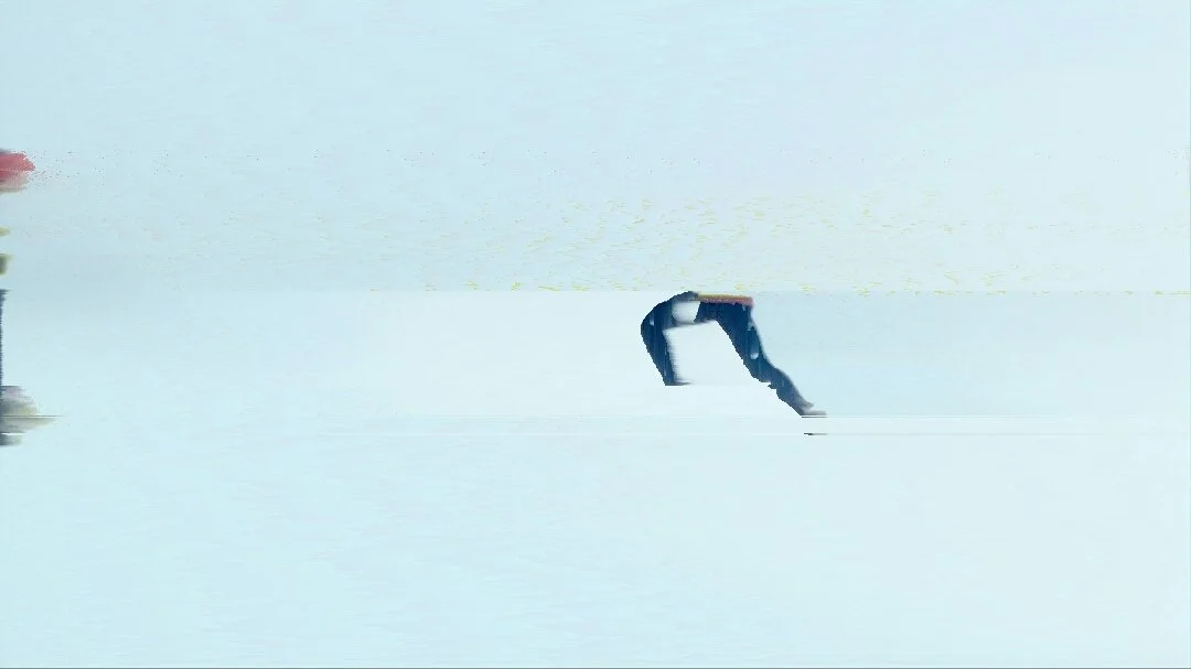 A person sitting on a ledge by a body of water, reading a book.
