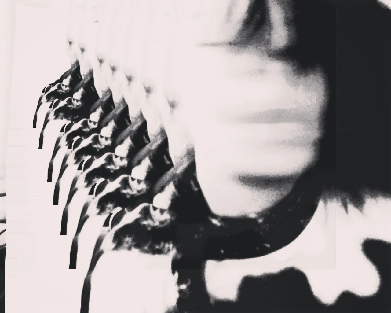 Black and white artistic image featuring a person with face partially visible and holding multiple copies of a magazine or poster showing a woman wearing sunglasses.