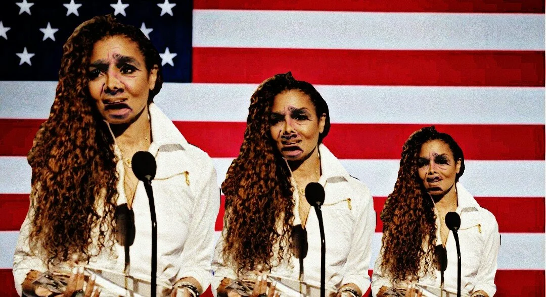 A woman with long, curly brown hair and a white jacket speaks at three different microphones with a large American flag in the background.