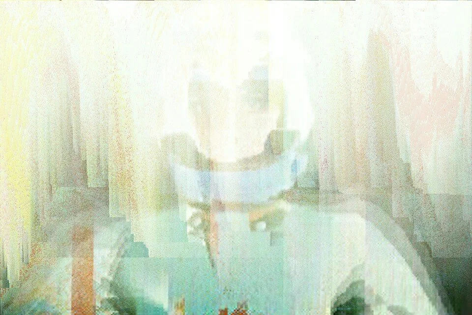A Pixelated and distorted face of a person wearing glasses and a cap.
