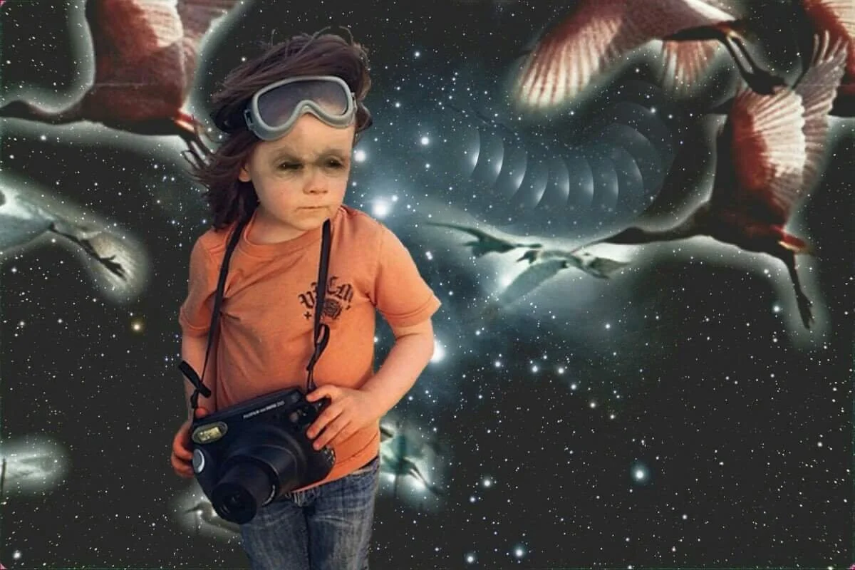 A young boy wearing a scuba-diving mask and carrying a camera, standing in front of a surreal cosmic background featuring flying dinosaurs and a spiral galaxy.
