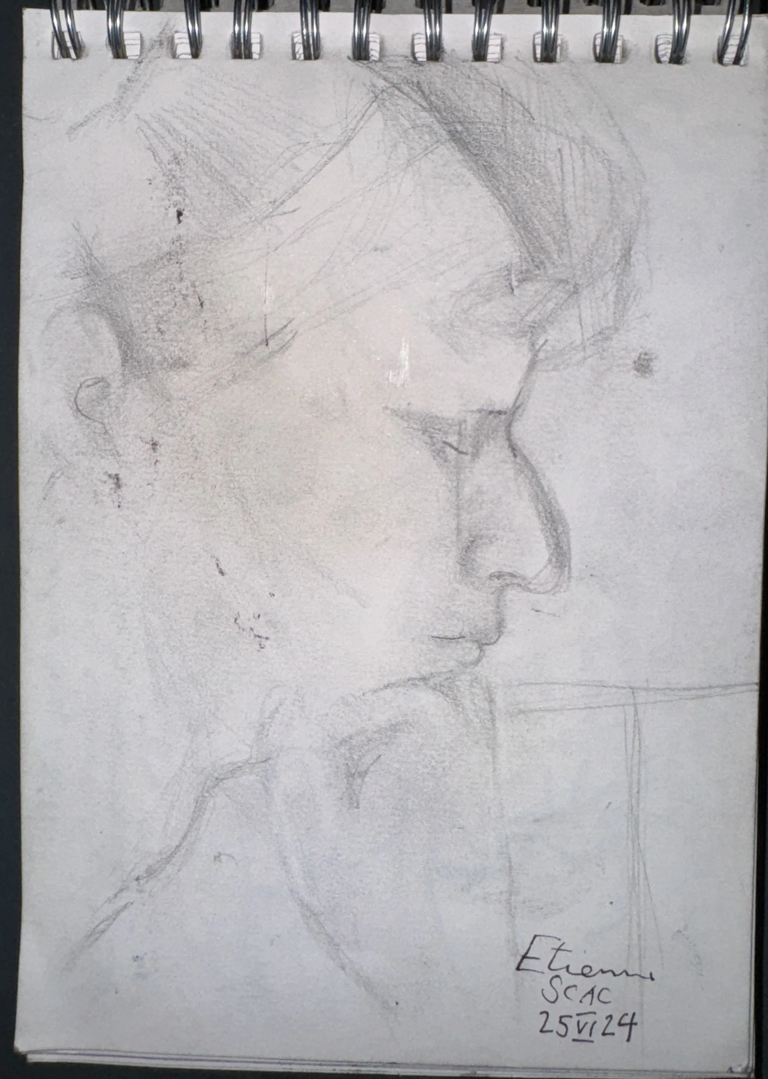 A pencil sketch of a woman's face in profile, showing her closed eye, nose, and lips. The drawing is on a spiral-bound sketchbook, with the artist's name 'Ettema' and date '25V24' written on the bottom right corner.
