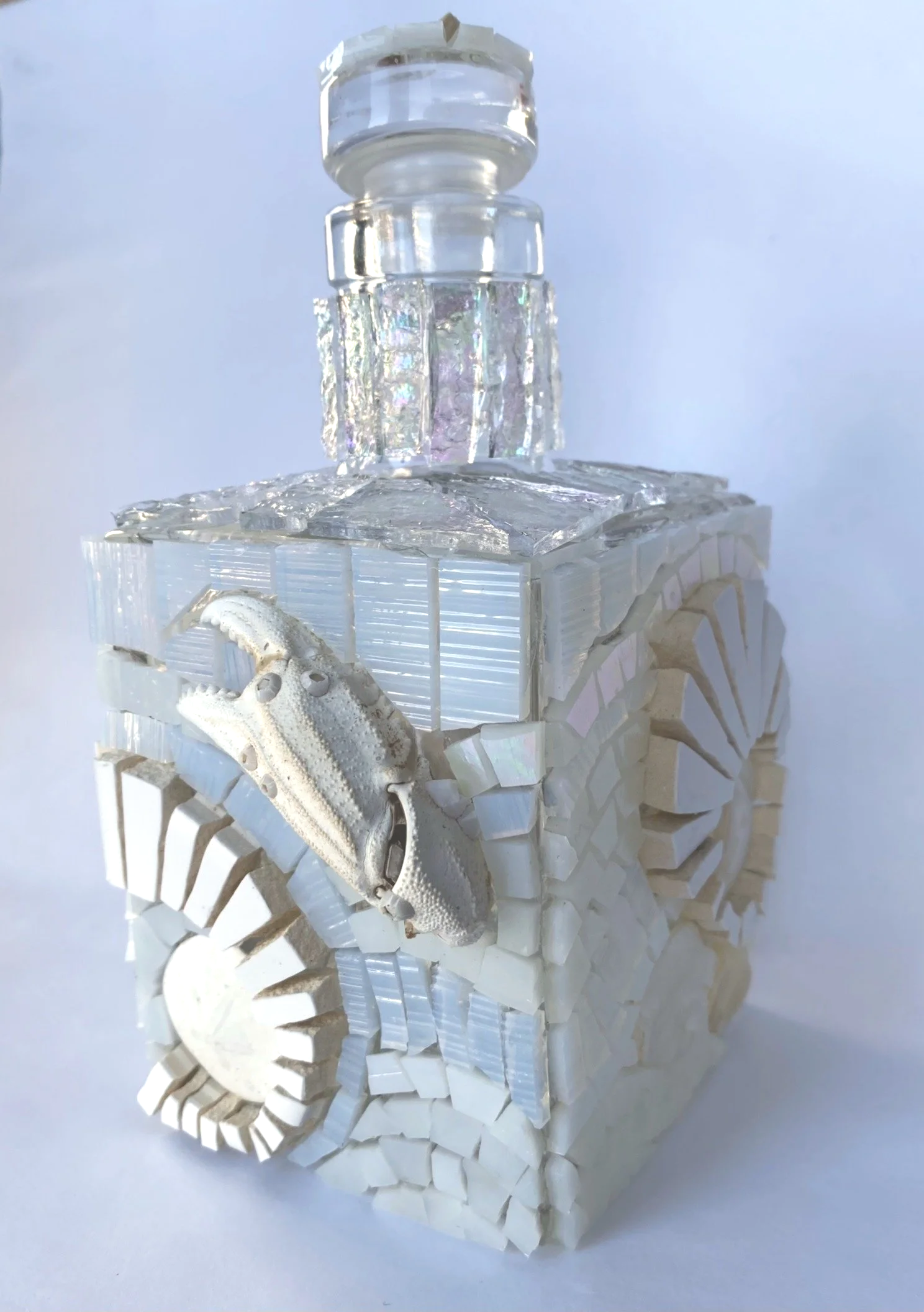 Sculpture made of white tiles, a small animal skull, and clear glass blocks, arranged to resemble a stylized animal.