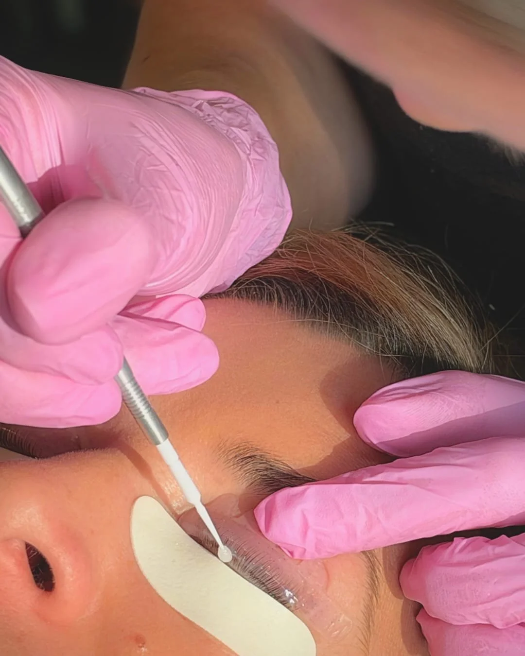 Bespoke eyebrow shaping and tinting treatment being performed by a professional beauty technician.