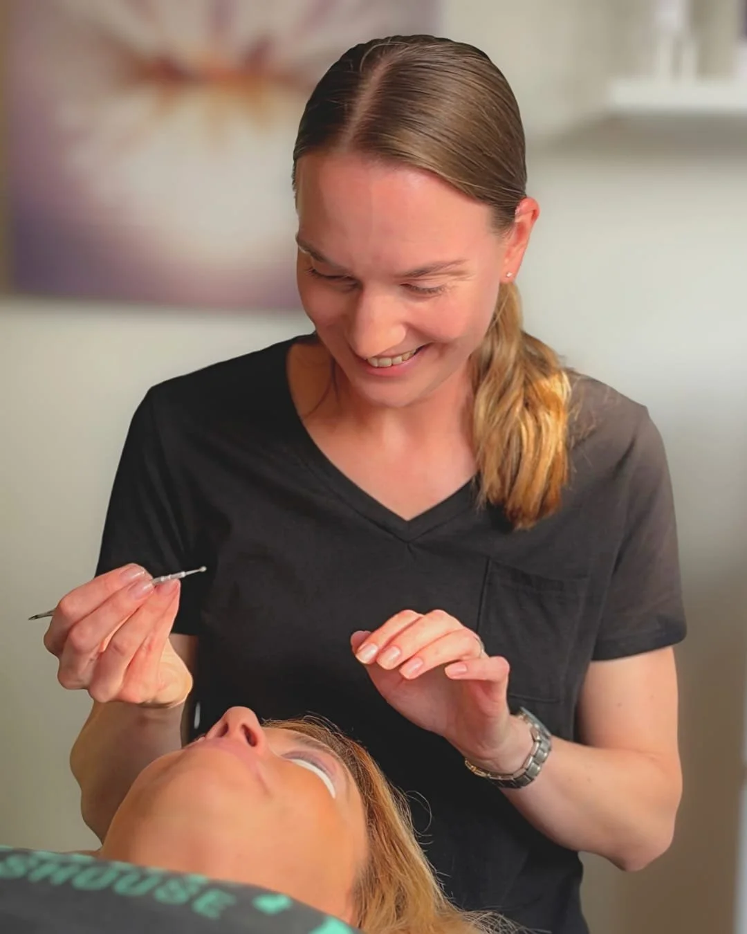 Anna-Maria Beauty technician smiling during a comfortable, personalized lash consultation with a client.