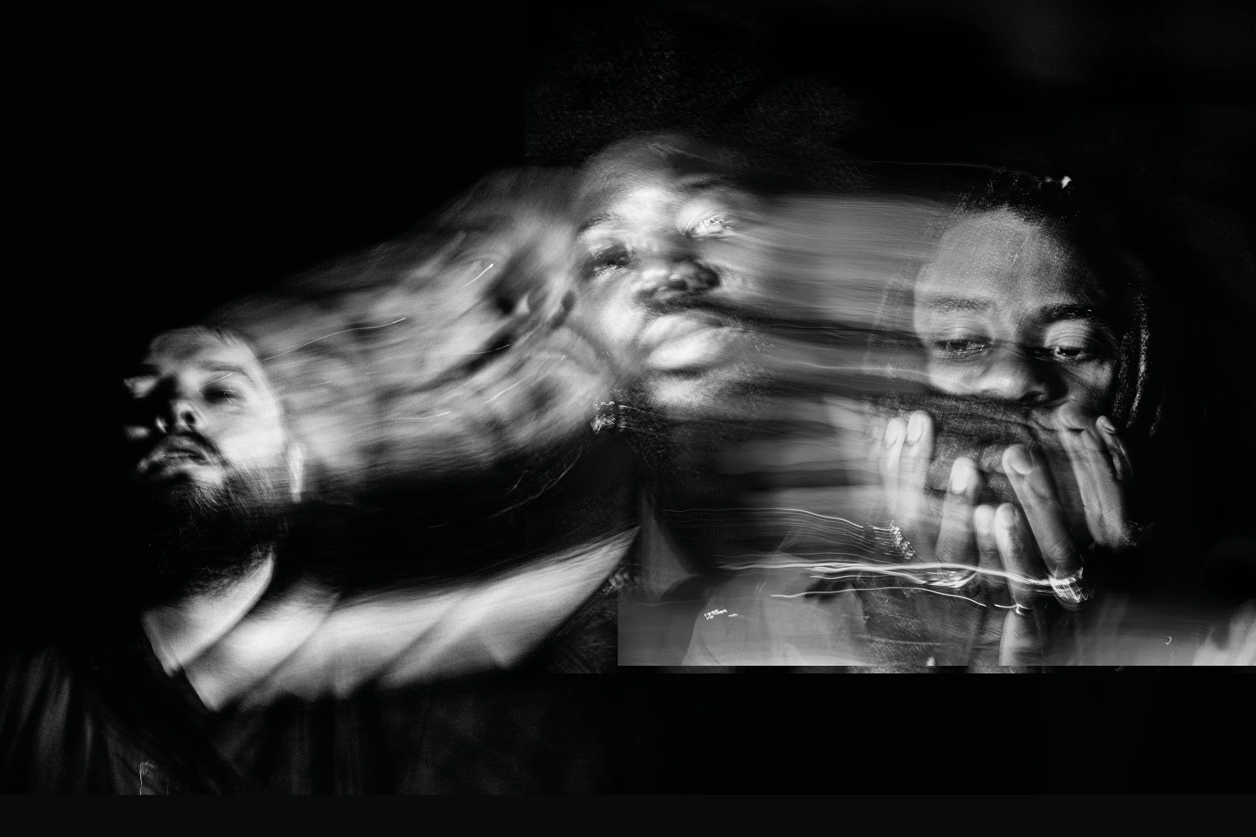 A blurry photograph in black and white of the band Young Fathers
