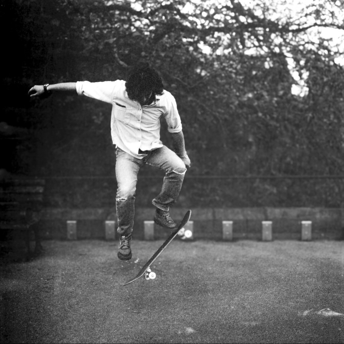 A person skateboarding outdoors in black and white.