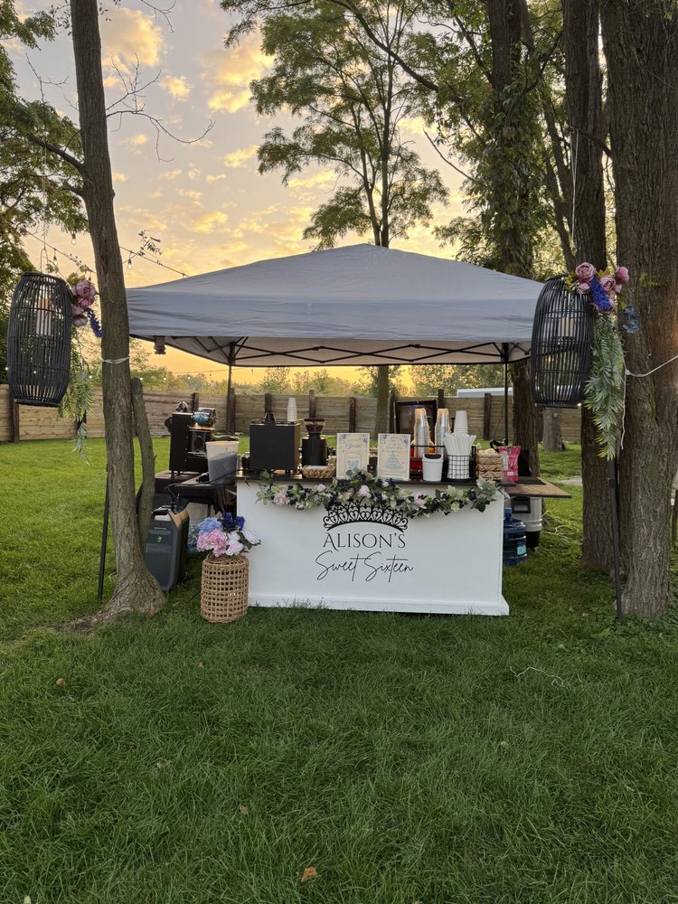 The Bravo Beans cart under a tent at an outdoor event at sunset
