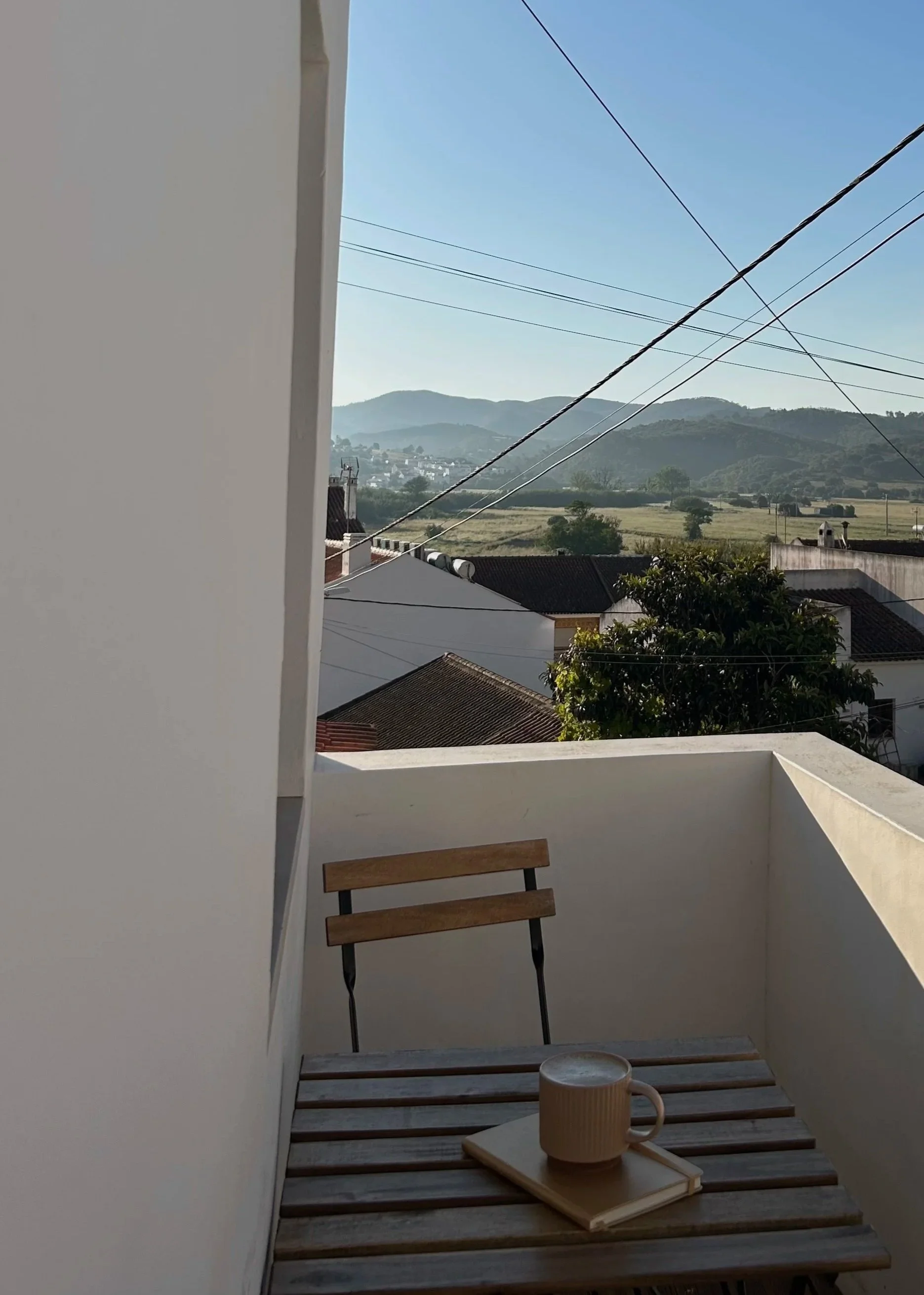 Coffee and notebook on table with mountain view, Aljezur, Portugal