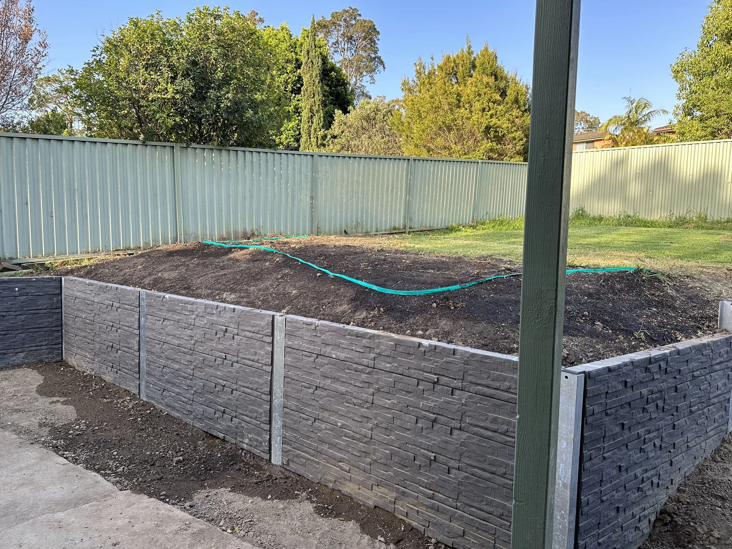Finished concrete sleeper retaining wall installed by SJB Civil Pty Ltd in Lake Macquarie.