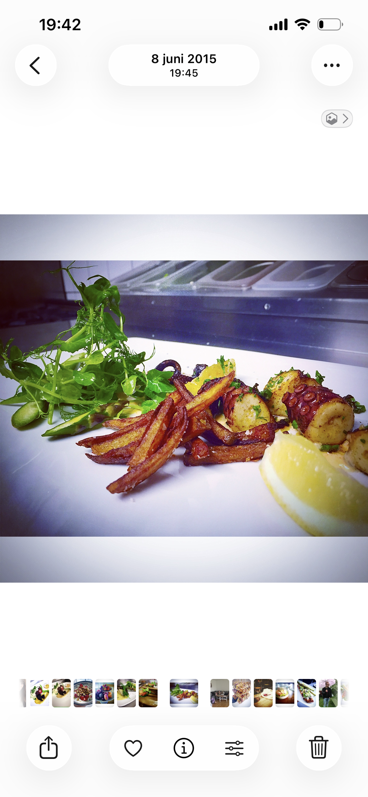 Tallrik med pulpo, sötpotatisfries, citronklyfta och blandad grönsallad
