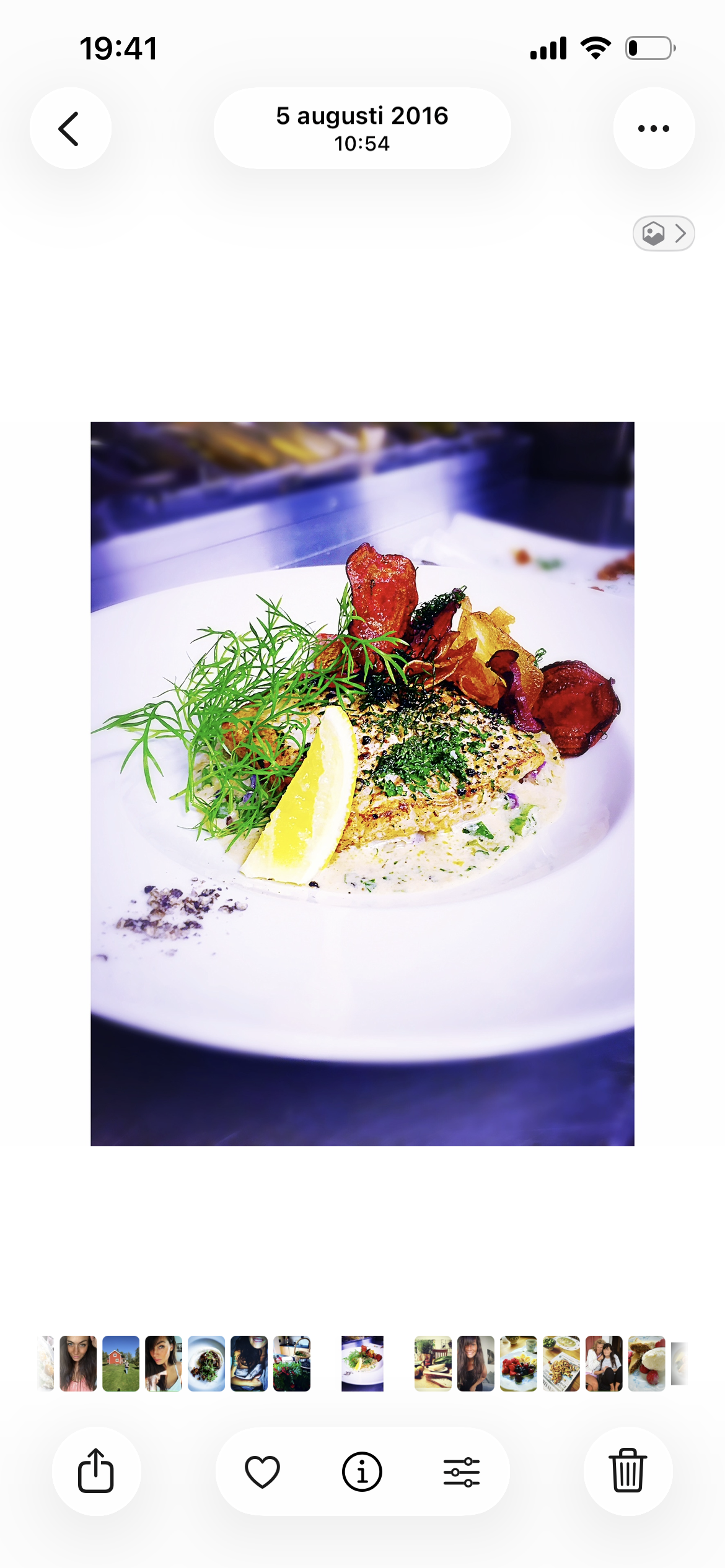 Fiskrätt med gräslök, citronklyfta, färska örter och bacon på tallriken.