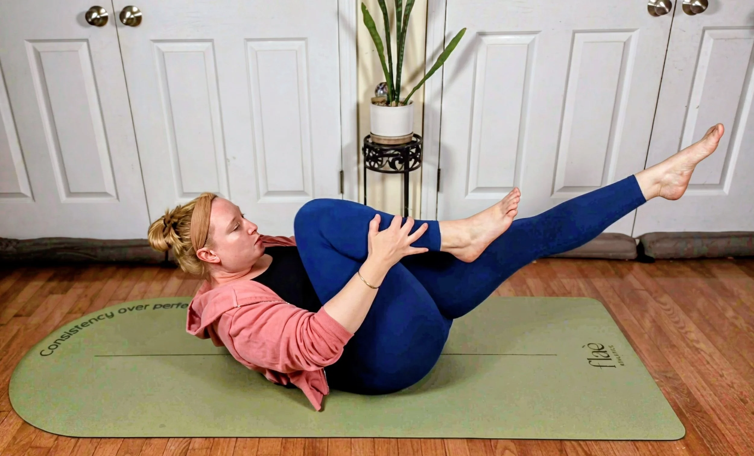 A client practicing mat Pilates core exercise in Revive Therapeutic Pilates studio.
