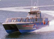 A blue boat moving through the water at high speed.