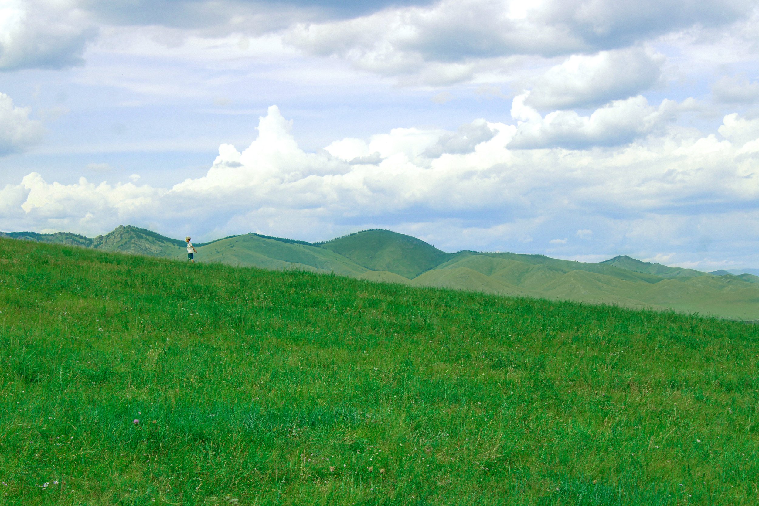 mongolia - a boy runs out in the hills