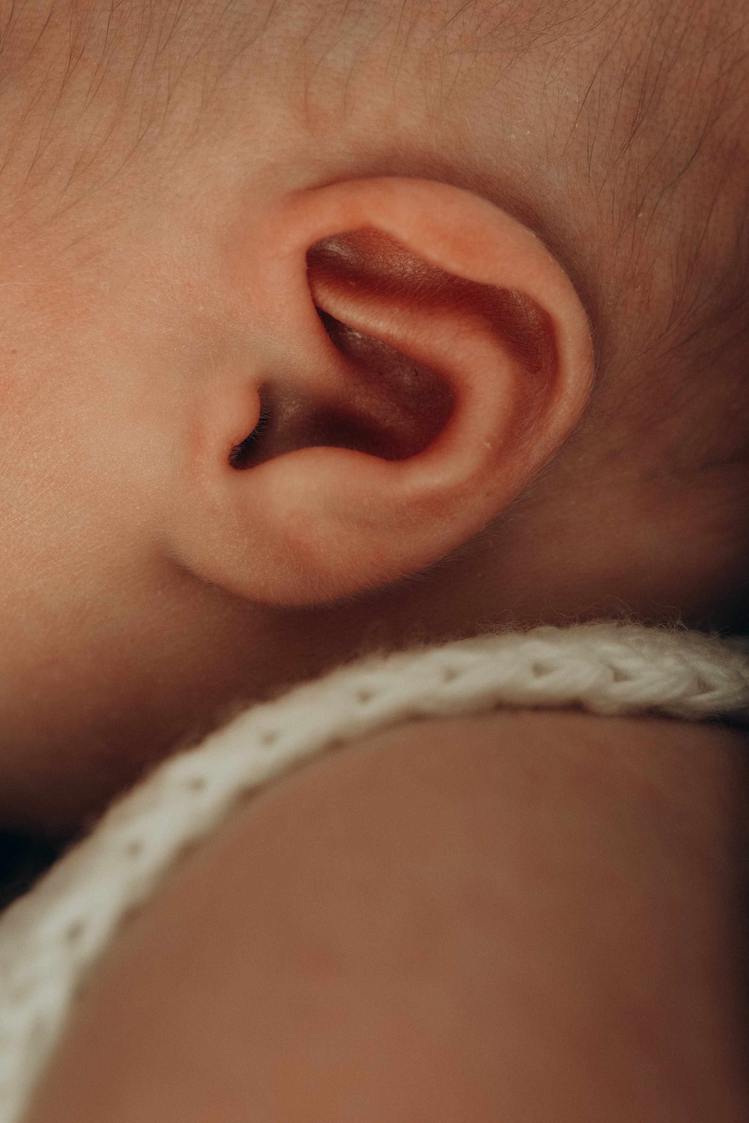 Nahaufnahme eines Ohr und eines Teils des Gesichts eines Babys.