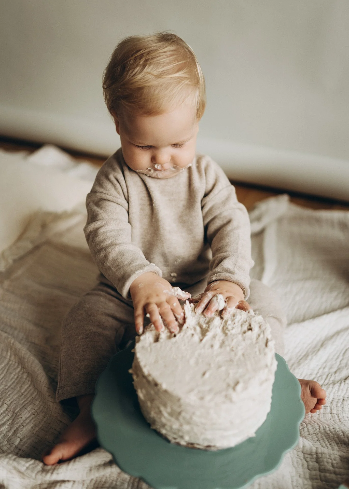 Kleines Kind backt einen Kuchen und hat Mehl im Gesicht, auf den Händen und auf dem Hemd.