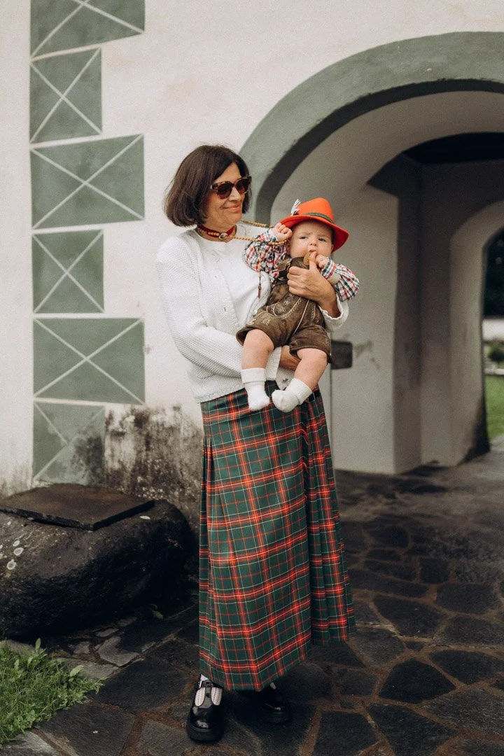 Eine stolze Oma trägt ihr Enkelkind bei den Gruppenaufnahmen des Tauffotoshootings in Kärnten.