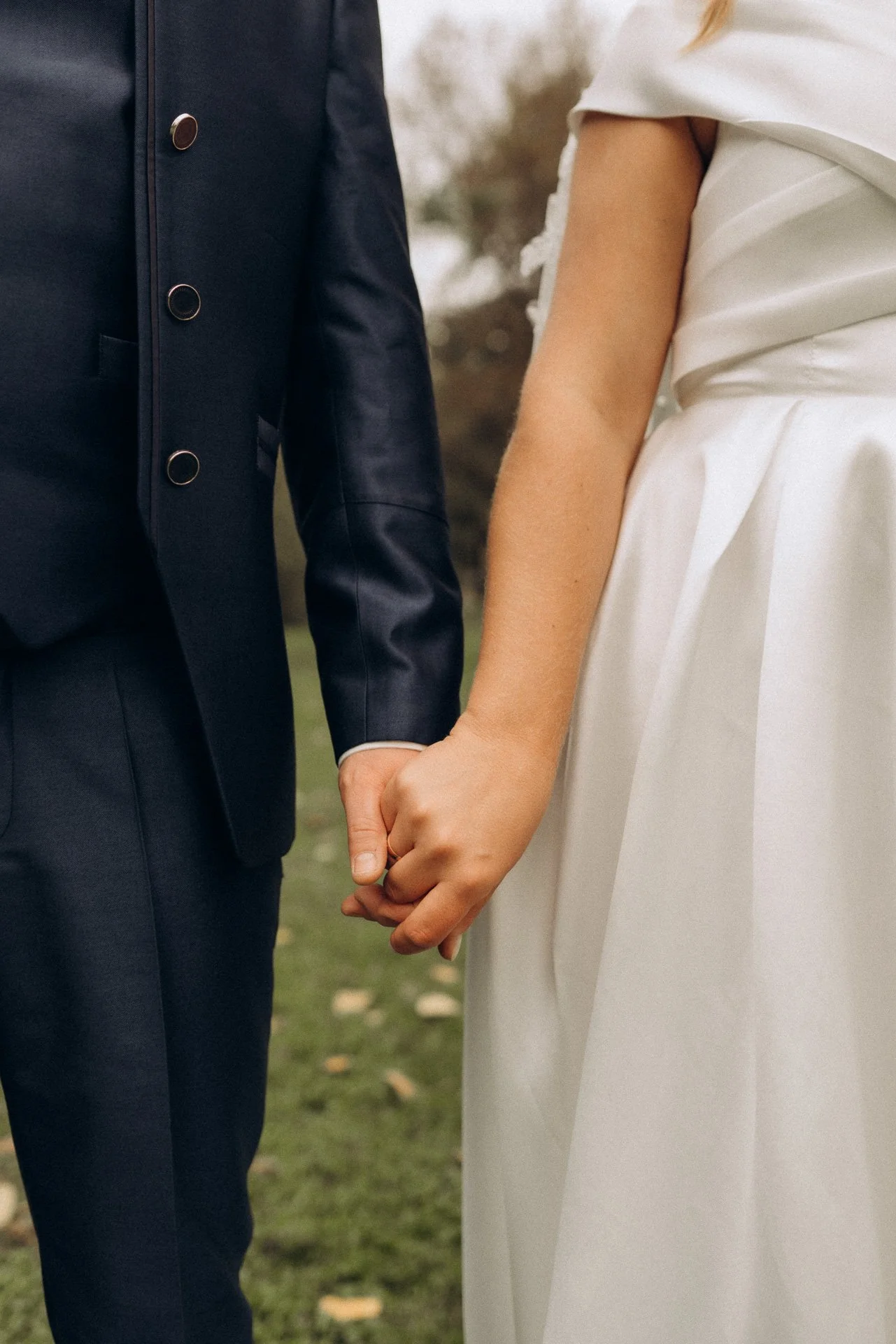 Ein Brautpaar hält sich an den Händen am Hochzeitstag während eines romantischen Hochzeitsfotoshootings in Kärnten.