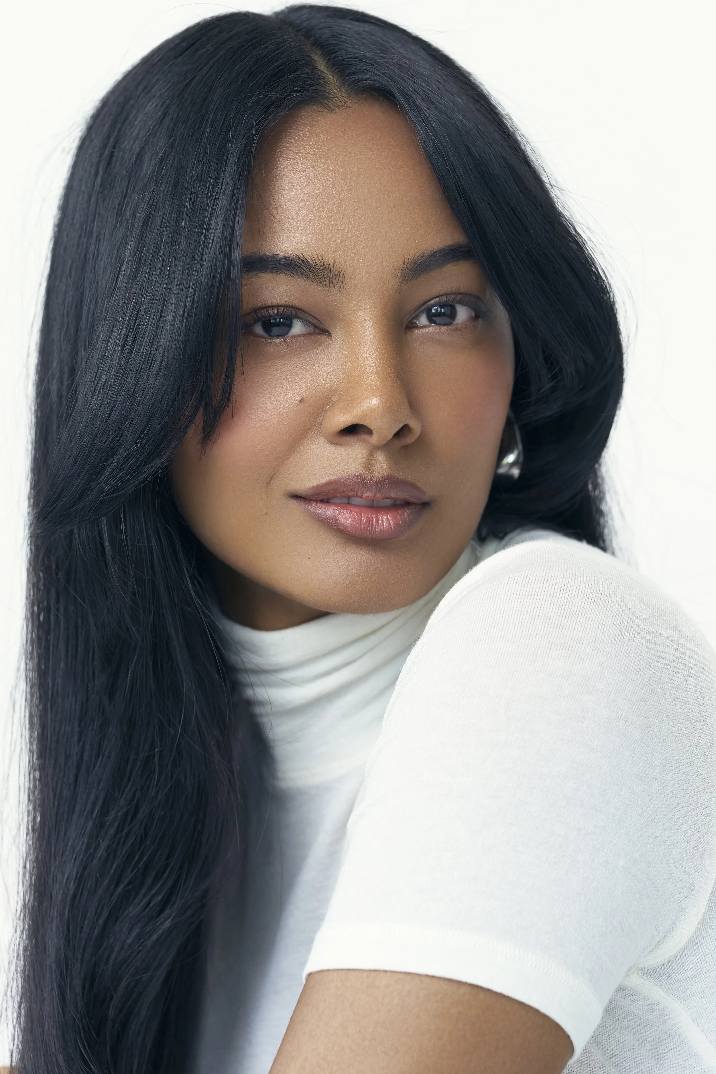 Commercial lifestyle and beauty portrait of London model Jennifer Elysee in white knitwear with natural makeup.