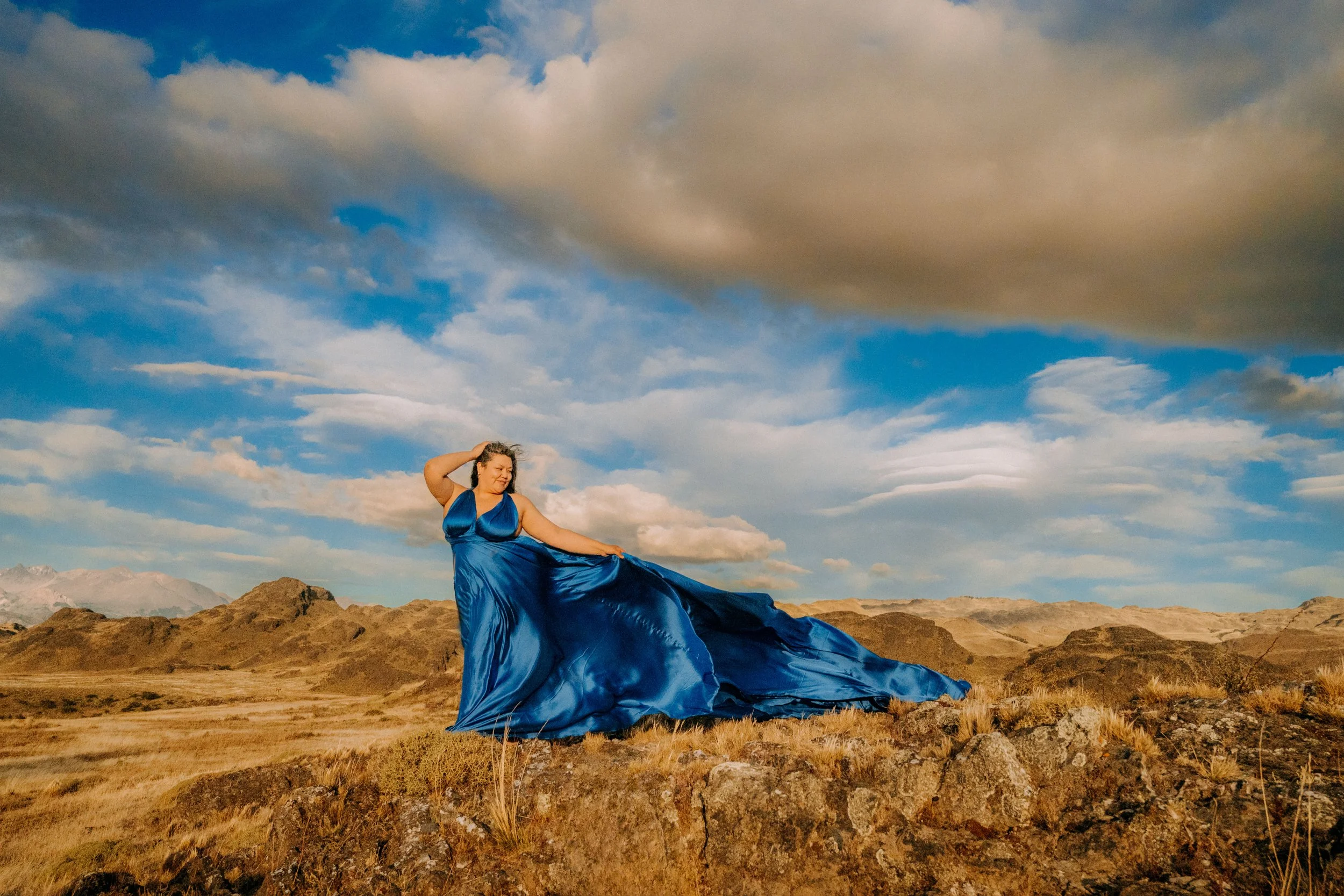 A woman in a flowing blue gown standing at Patagonia National Park