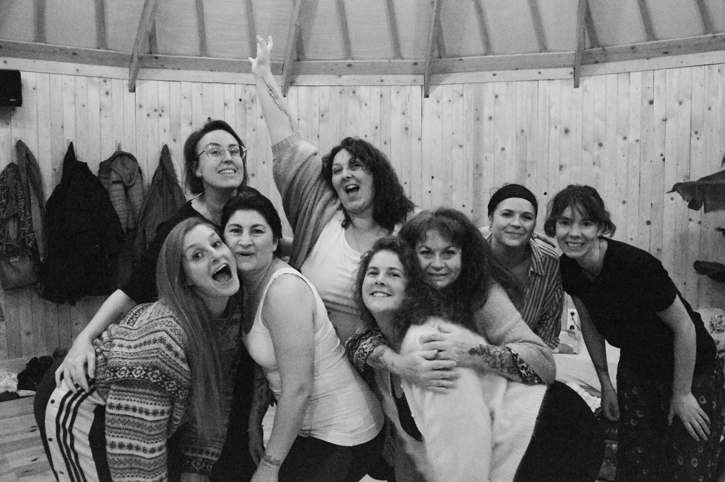 Groupe de personnes souriantes et joyeuses posant ensemble dans une pièce en bois