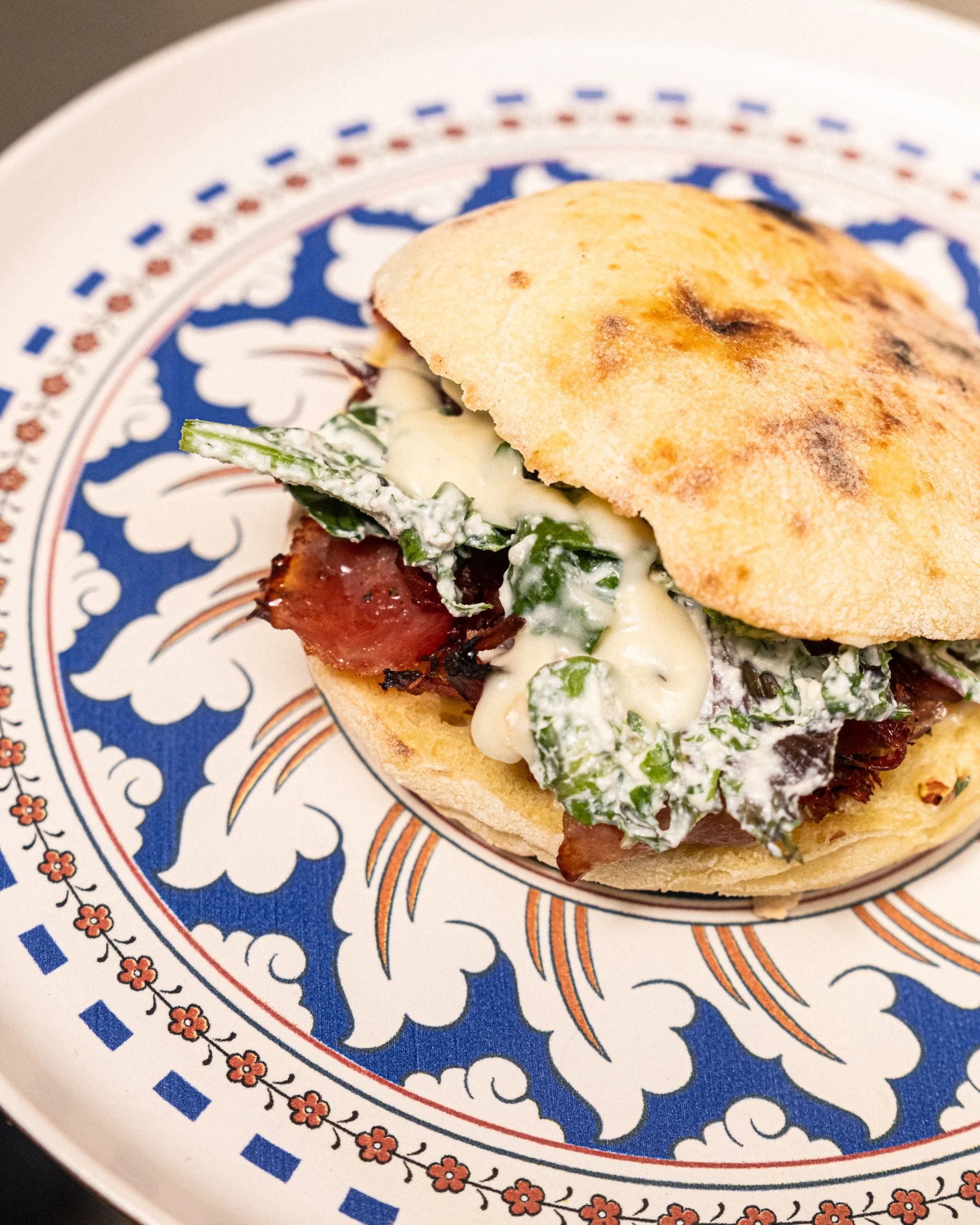 La Puccia Prima de Giola : jambon grillé aux herbes de Provence et au miel, béchamel de comté affiné, crème de ricotta à la ciboulette, mâche nantaise et jeunes pousses. Une création généreuse et gourmande à découvrir au 11 bis rue de la Bastille.