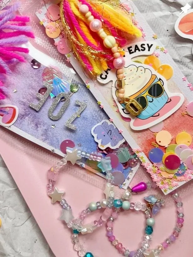 Bunte Dekoration mit Kerzen, Konfetti, Perlenarmbändern, Papierhasen, einem Geburtstagskuchen mit Sonnenbrille, und der Zahl 07 für eine Feier.