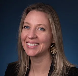 Headshot of smiling female tutor with short blonde hair wearing a lanyard.