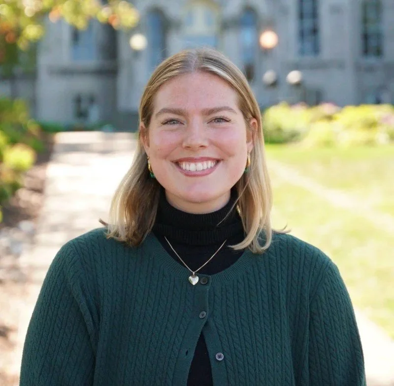 Headshot of smiling female tutor with long braids wearing a lanyard.