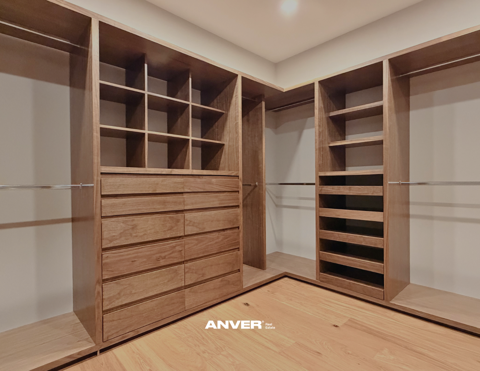 Armario de madera con estantes, cajones y barras para colgar ropa, en una habitación con suelo de madera.