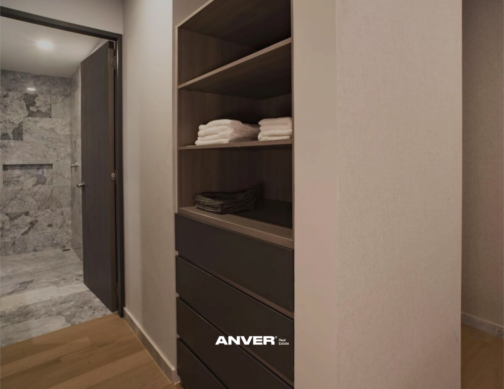 Estante de almacenamiento con toallas blancas y ropa en una habitación moderna.