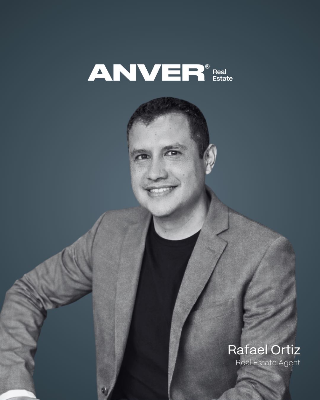 Retrato de Rafael Ortiz, un agente de bienes raíces, en una foto en blanco y negro con fondo azul oscuro, usando chaqueta gris y camiseta negra, con texto que dice «ANVER Real Estate».